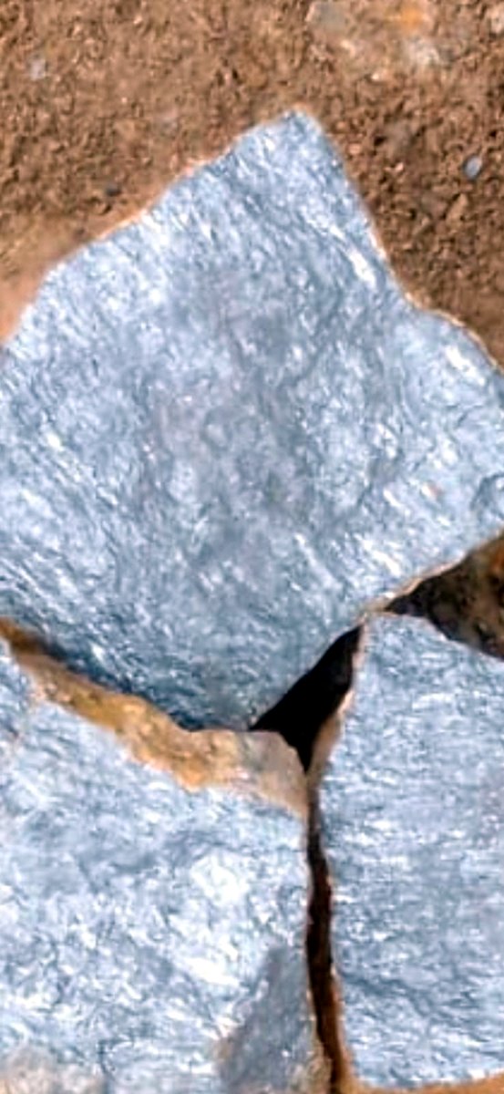 Freshly broken raw antimony ore showing bright metallic grey faces