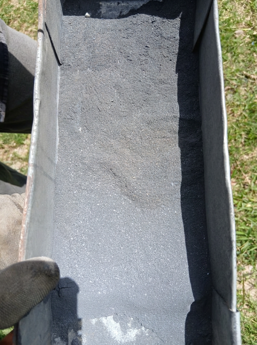 Fine grey ore particles spread across a processing trough